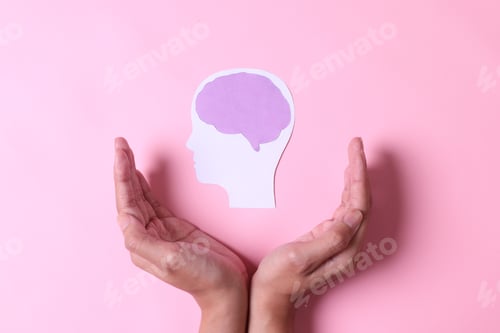 Preview: Hands with brain paper cutout isolated on pink background.