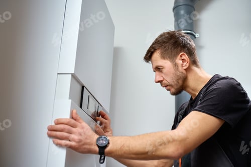 Preview: Man adjusting control panel of heat pump during installation