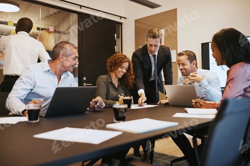 Preview: Smiling businesspeople meeting together in an office boardroom
