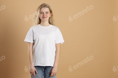 Preview: Young woman wearing blank white t-shirt on light brown background. Mockup for design