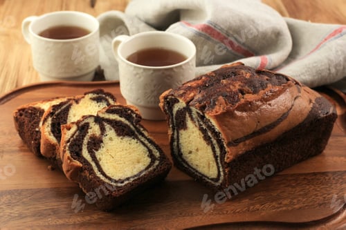 Preview: Sliced Loaf marble Cake on White Plate, Wooden Table. Homemade Baked Goods