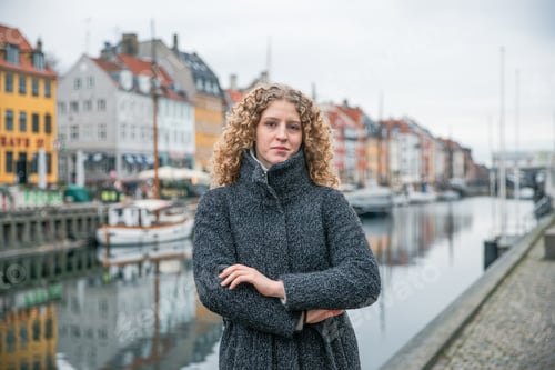 Preview: Young girl with her arms folded in Copenhagen during a winter morning.