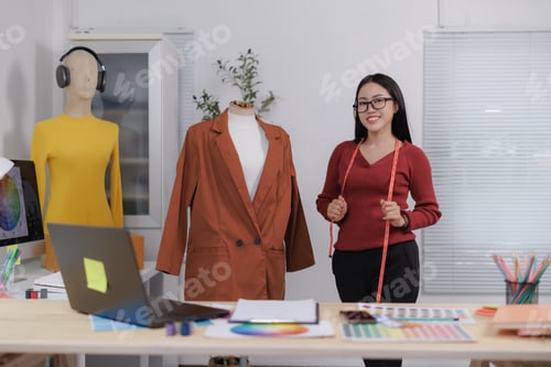 Preview: Fashion designer holding measuring tape and working in her studio
