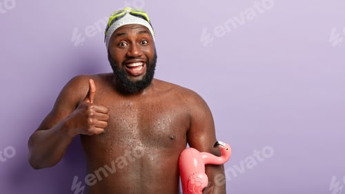Preview: Athlete swimmer with dark skin, has wet body after swimming, keeps thumb up, says weather is excelle