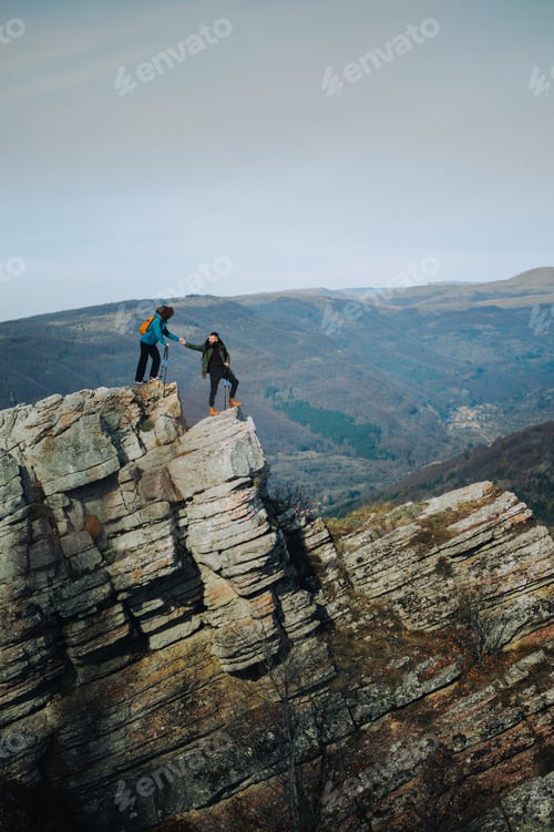 Preview: Hikers helping each other on dangerous mountain peak