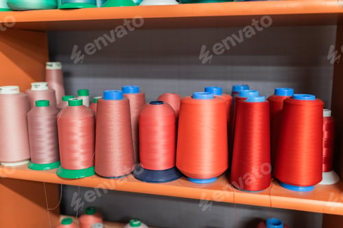 Preview: Colored spools of thread on wooden shelf