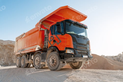 Preview: Large orange dumper truck working in a quarry transporting sand and gravel
