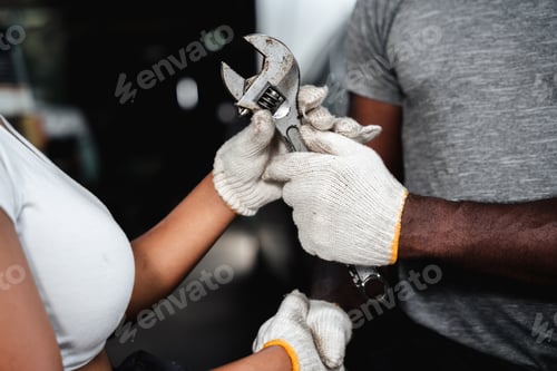 Preview: Close-up mechanic hand with his tool holding a spanner while at a garage.