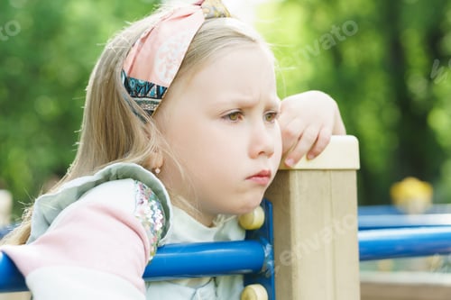 Preview: Portrait of sad little girl in a city park