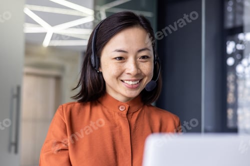 Preview: Close-up photo of young beautiful Asian woman talking on video call, looking at laptop web camera