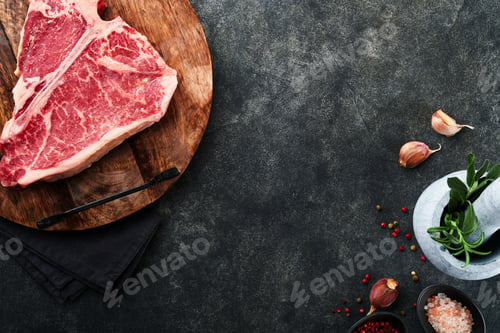 Preview: Thick Raw T-Bone Steak. Dry-aged Raw T-bone or porterhouse beef meat Steak on cutting boar with herb