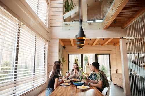 Preview: Group of friends eating and talking on the kitchen
