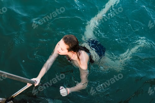 Preview: Teenage girl swimming in the sea. Summertime, outdoor activity, vacation, travel, sport concept. N