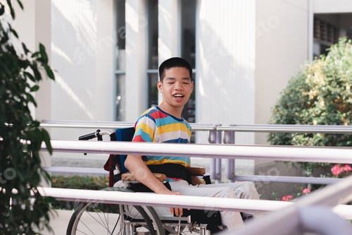 Preview: special child on wheelchair is smiling face as happiness on ramp for disabled people in hospital