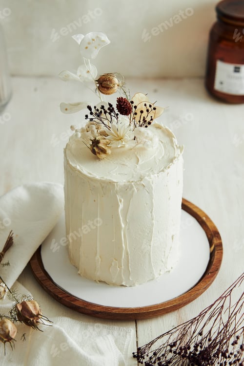 Preview: Top view of delicious Boho ombre cake with dry flowers on a white table