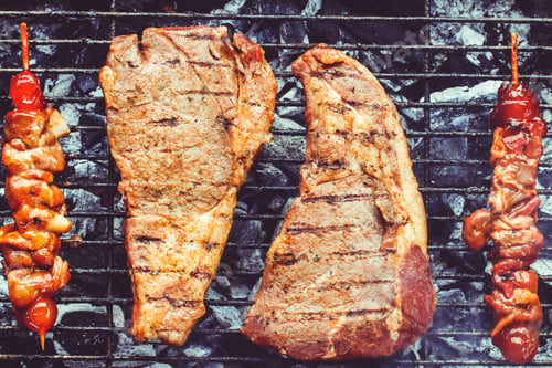 Preview: Closeup of t-bone steaks and barbecue on a grill