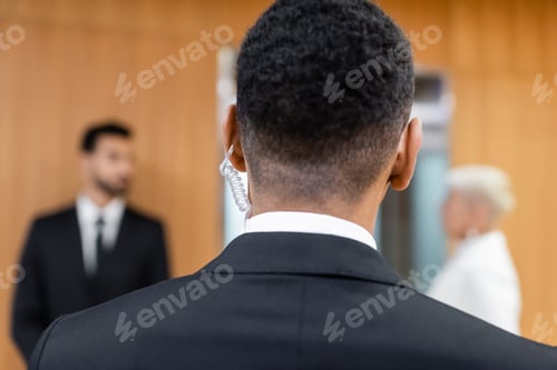 Preview: back view of african american security man near blurred senior woman with bodyguard on blurred