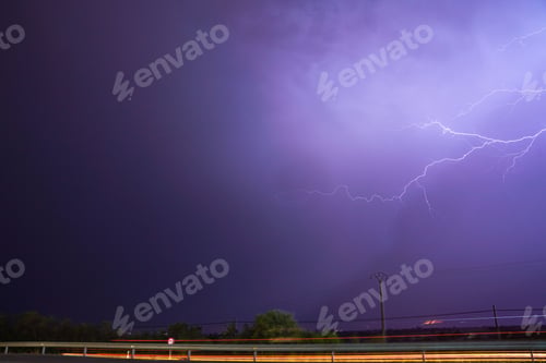 Preview: the lightning is in the sky over a street with cars driving