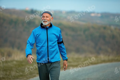Preview: Happy senior sportsman taking a walk in nature.