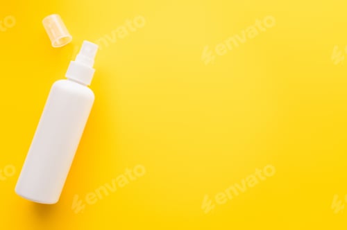 Preview: Top view of sunblock with cap on yellow surface