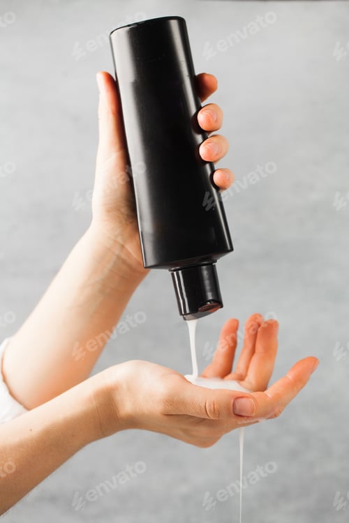 Preview: Hands Pours Lotion from Black Bottle