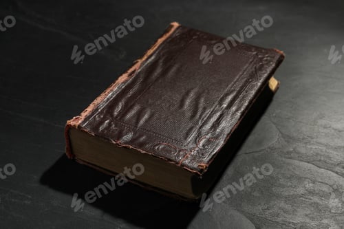 Preview: One old hardcover book on black textured table