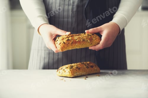 Preview: Woman hands holding freshly baked bread. Bun, cookie, bakery concept, homemade food, healthy eating