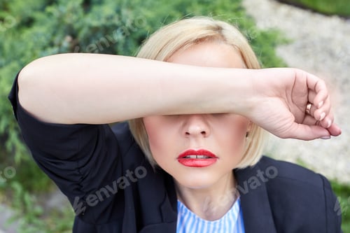 Preview: Depressed. Woman covers her face with her hand from fatigue in the middle of the working day