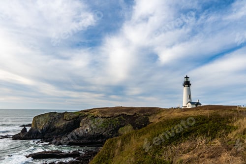 Preview: White lighthouse on the coast against the cloudy sky in summer