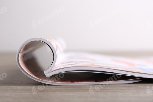 Preview: One open magazine on wooden table, closeup