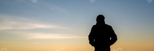 Preview: Wide backlit view on person with hands in pockets