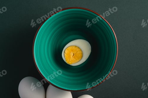 Preview: Boiled egg with yellow yolk in green bowl