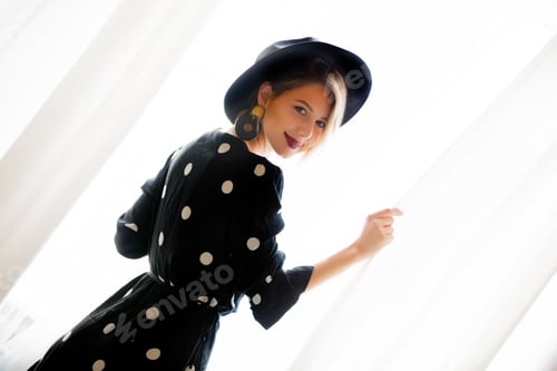 Preview: Young girl in black stay near window.