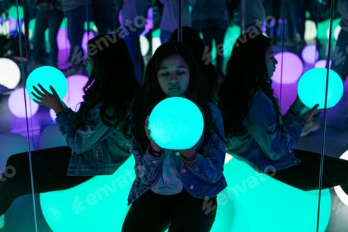 Preview: Girl in a room full of mirrors holding a light ball