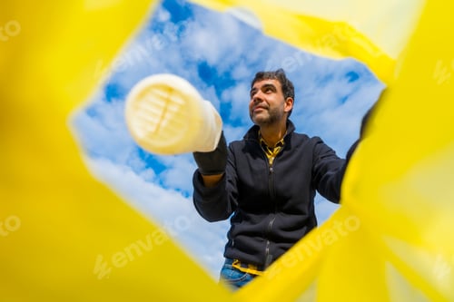 Preview: Volunteer throwing a plastic bottle into a garbage bag on the beach. Ecology, Sea pollution