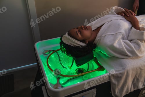 Preview: Customer relaxing during innovative pressurized water hair treatment in beauty salon