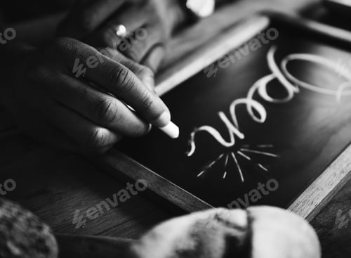 Preview: Closeup of hands writing open word on chalkboard