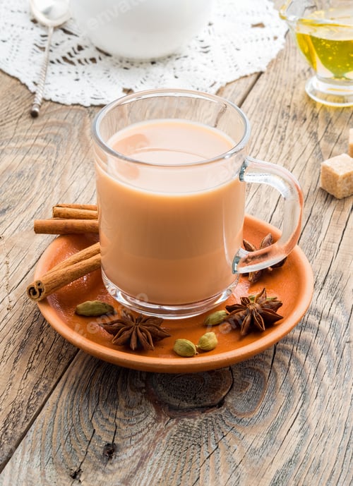 Preview: Masala Indian drink in the festival of Holi. Tea with milk and spices in a glass mug.