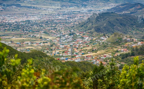 Preview: Panoramic view of a small town in Tenerife nestled in a valley surrounded by hills and greenery