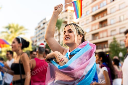 Visualização: Ativista transgênero agitando a bandeira do orgulho transgênero na parada do orgulho