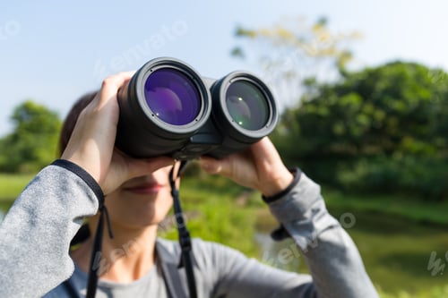Preview: Woman looking though binoculars