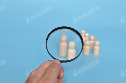 Preview: Wooden doll figures and magnifying glass. Recruitment, hiring and leadership concept.