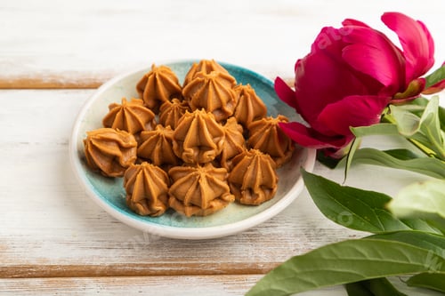 Preview: Homemade soft caramel fudge candies on white wooden, side view