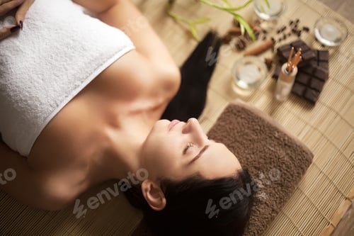 Preview: Top view of pretty woman laying in spa salon with closed eyes and relaxed