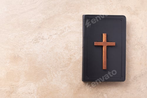 Preview: Wooden cross on Bible over marble background. Reminder of Jesus sacrifice and Christ resurrection