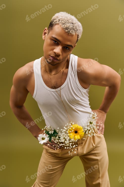 Preview: Young man in trendy tank top adorned with flowers creates a unique studio vibe