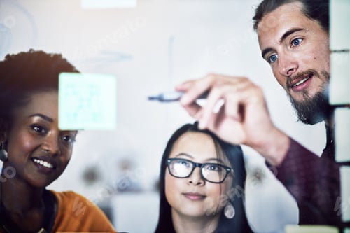 Preview: Cropped shot of a group of businesspeople working on a glass wall the office