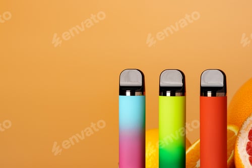 Preview: Three electronic cigarettes with citrus fruits on orange background