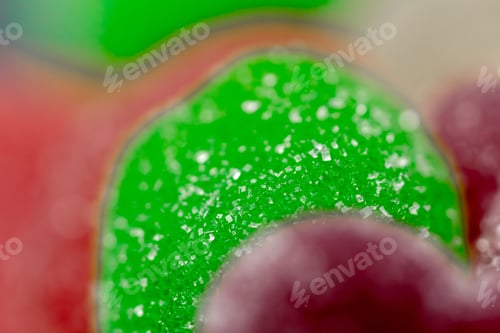 Preview: very close-up on black long plate multi-colored sweet jellies sprinkled with sugar assorted fruits a