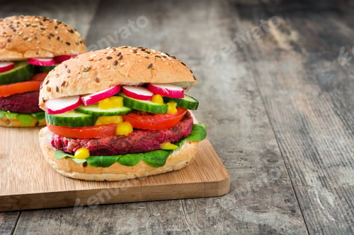 Preview: Tasty beetroot veggie burger with fresh vegetables on rustic wooden table